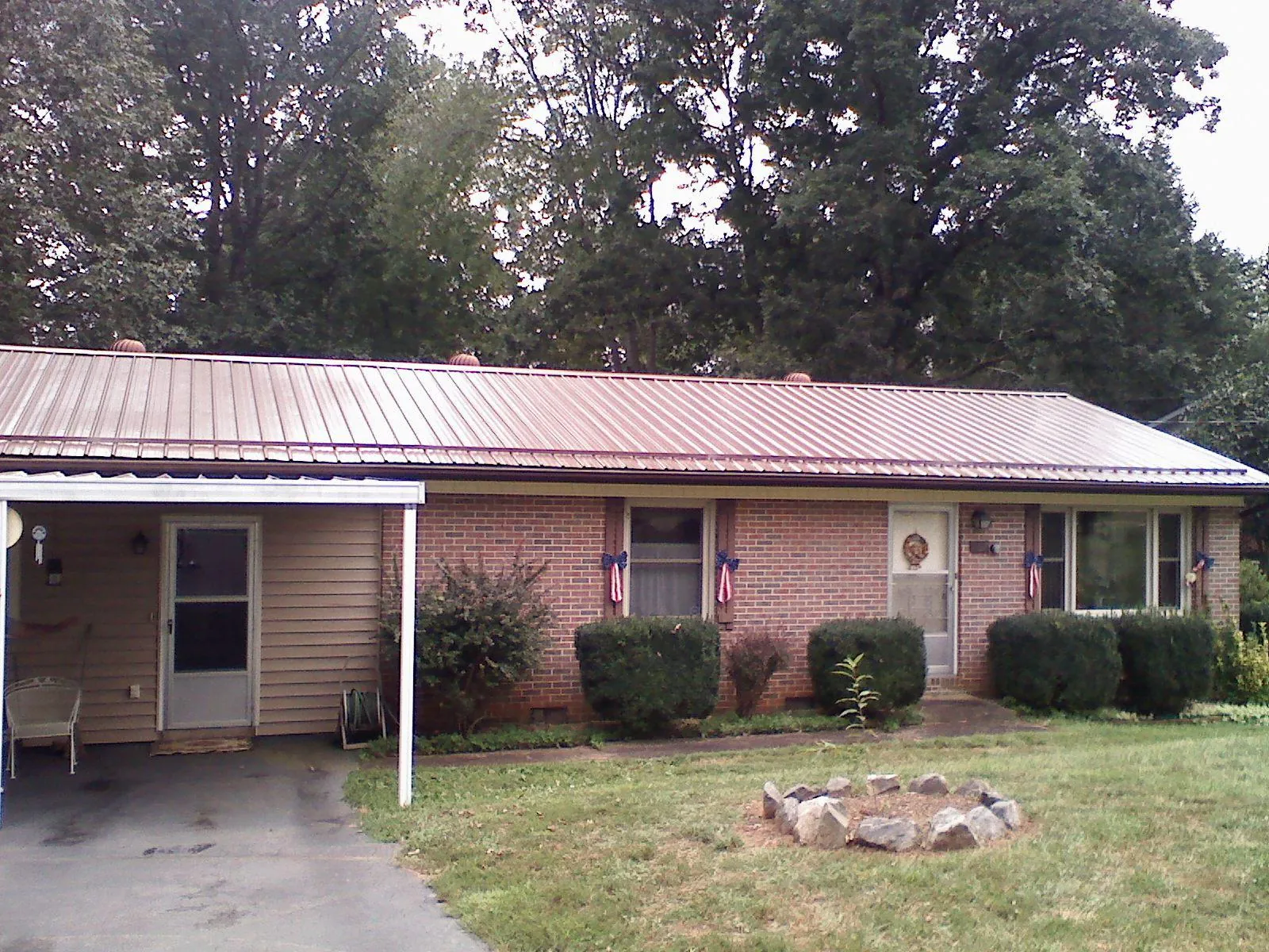 Bronze metal roof and carport on a brick ranch home — Roof Repair work by our crew in Metaline Falls