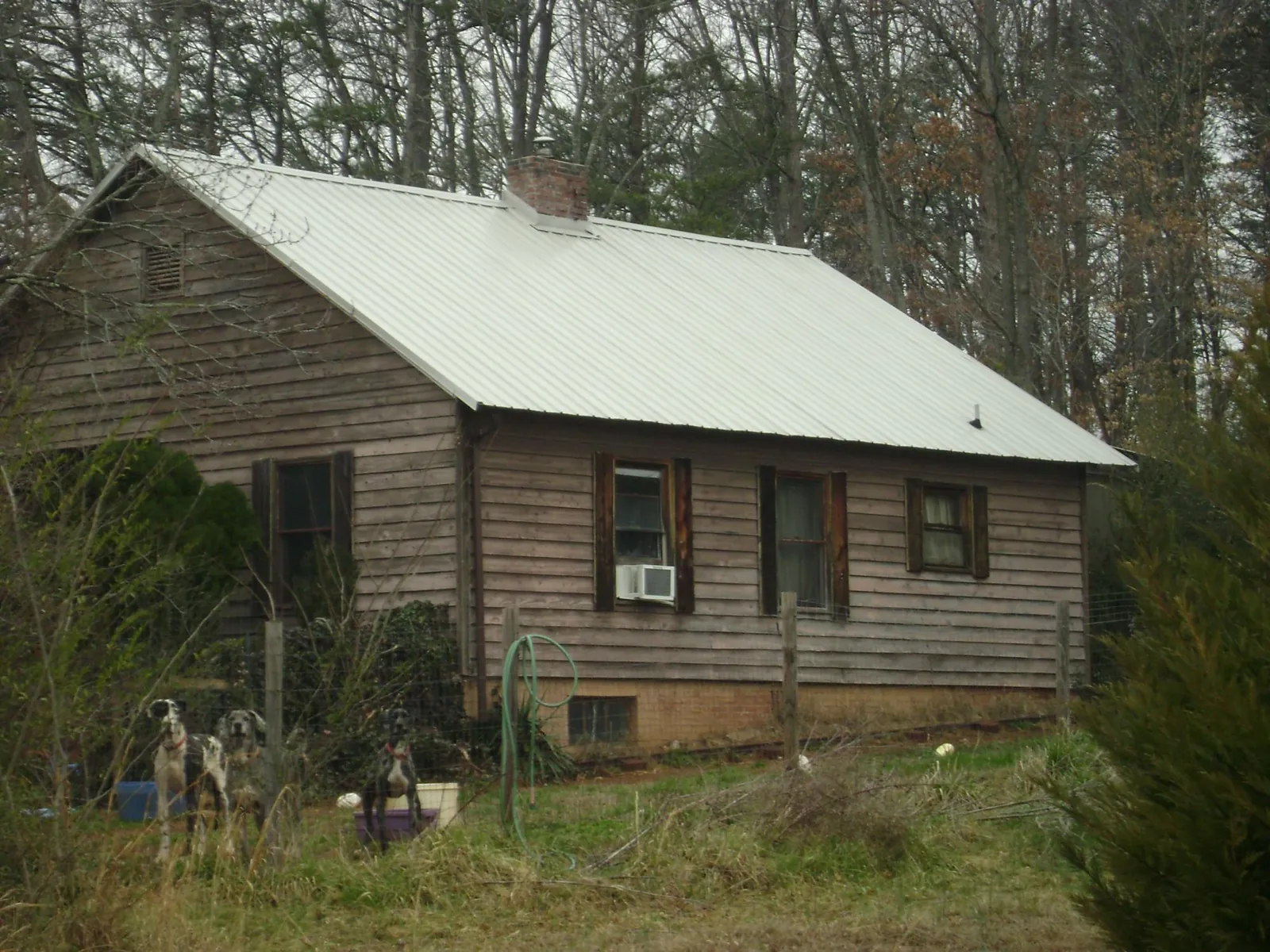 White metal roof on an old wood sided farmhouse, from a Metal Roof Installation job in Metaline Falls